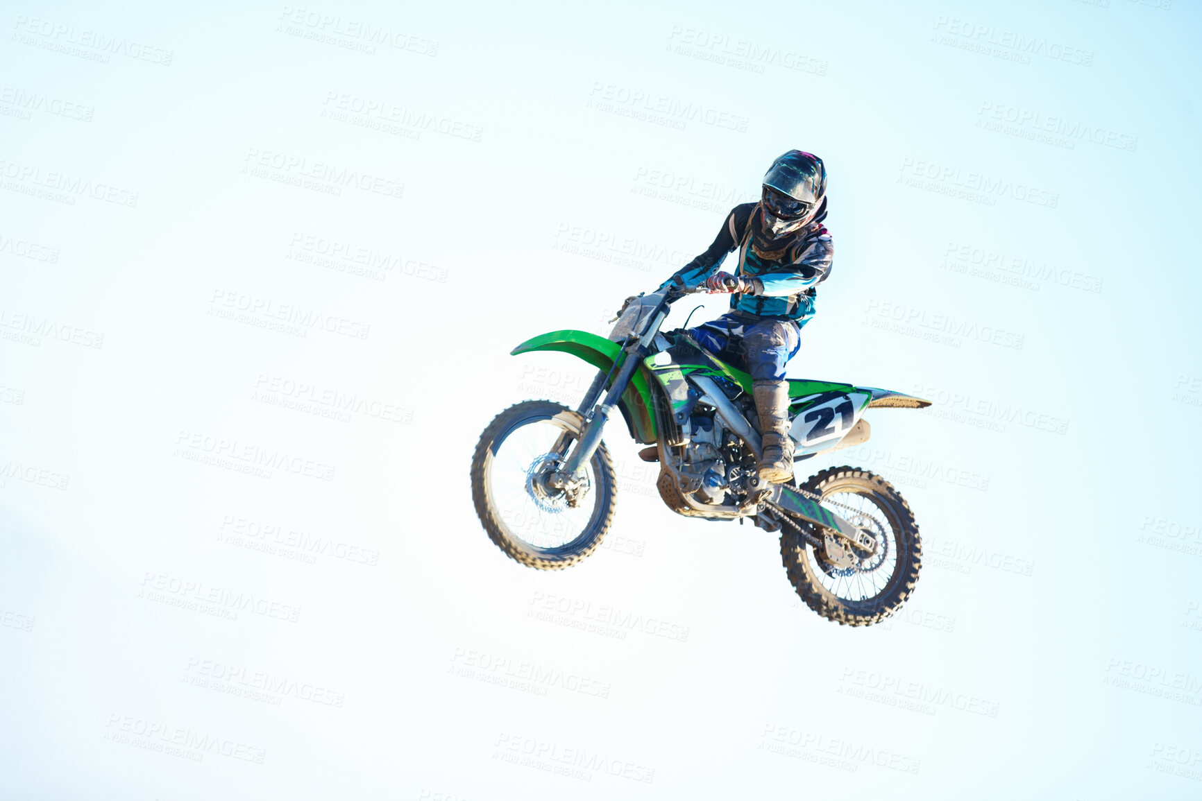 Buy stock photo Person, motorcycle and air stunt in blue sky as professional in action, competition or fearless. Bike rider, off road transportation jump or fast speed adventure at rally, outdoor challenge or race