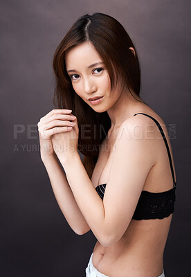 Buy stock photo Asian woman, tattoo and serious portrait in studio, dark background and show art on skin. Japanese, model and unique ink on body with lady in jeans, shorts and underwear with style and pride