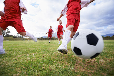 Buy stock photo Running, teamwork and closeup with children and soccer ball on field for training, competition and fitness. Game, summer and action with football player and kick on pitch for goals, energy or athlete