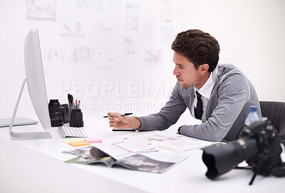 Buy stock photo A photographer looking at his images in his office