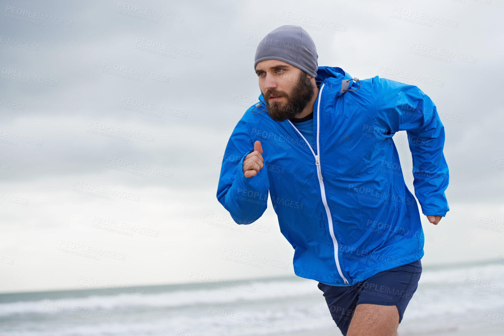 Buy stock photo Beach, man or running for exercise, wellness or training outdoor in nature to workout for body health. Ocean, athlete or person jog for fitness, cardio or sport with energy at sea in winter on mockup