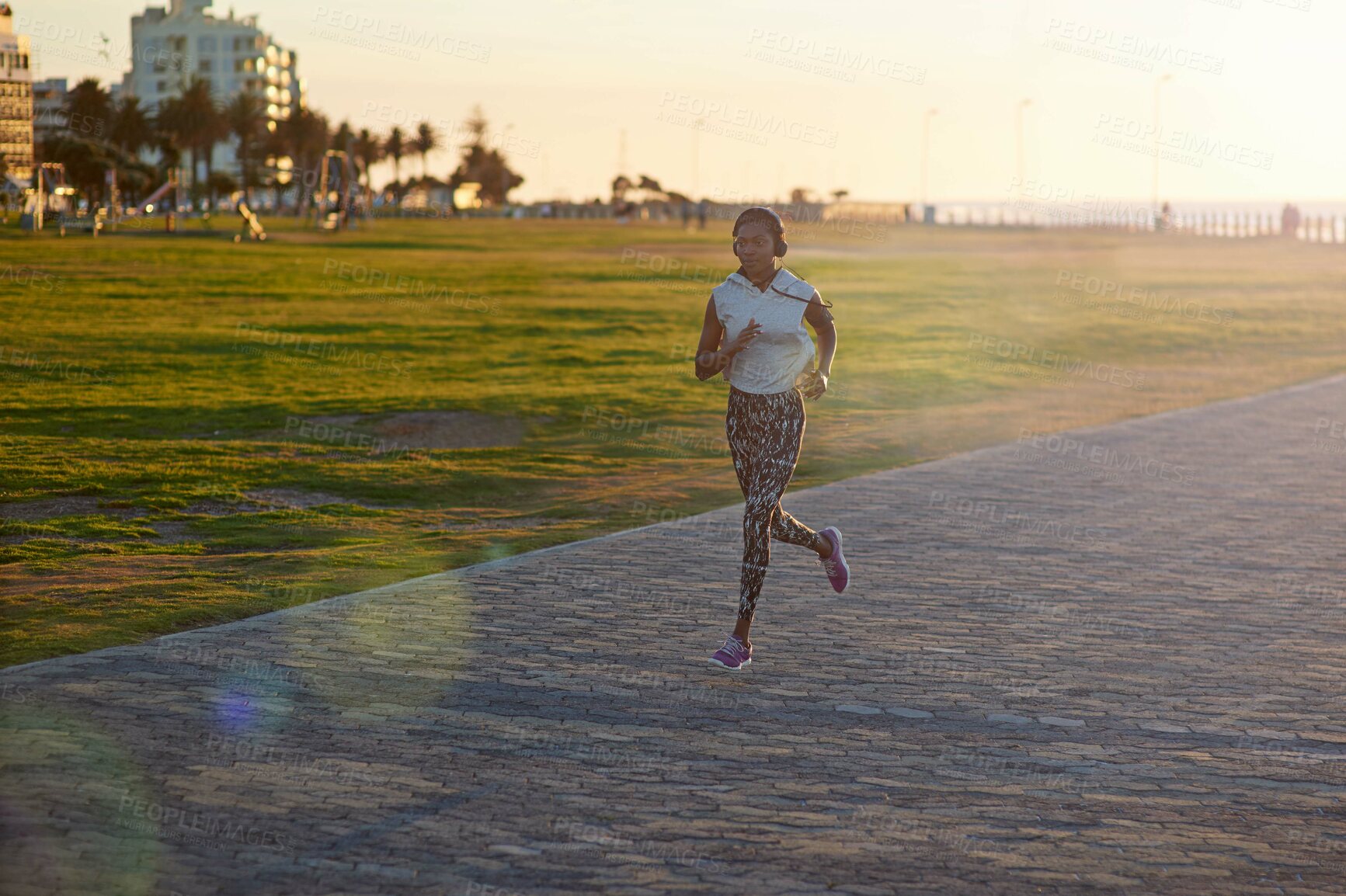 Buy stock photo Black woman, running or outdoor with music for fitness, exercise or cardio training. Girl, headphones or jog on Mozambique promenade for workout, challenge and lose weight with motivational podcast