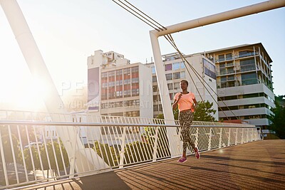 Buy stock photo Black woman, runner and fitness with bridge in city for cardio exercise, workout or outdoor training. Young African, female person or running with asphalt or path for race, sprint or marathon in town