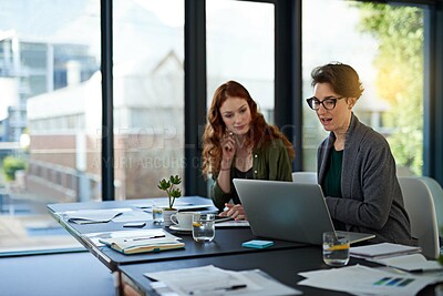 Buy stock photo Cropped shot of colleagues working together on a laptop in a modern office