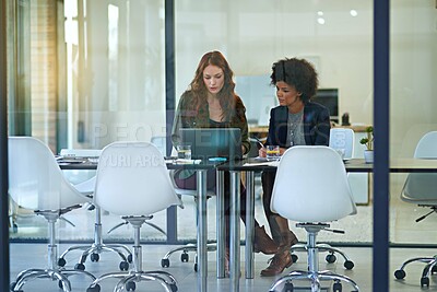 Buy stock photo Shot of colleagues working together on a laptop in a modern office