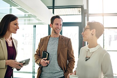 Buy stock photo Shot of a group of colleagues talking together in a large modern office