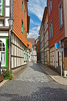 Road, brick or path by houses for architecture, buildings or travel or exploration in Germany. Outdoor, city or street walkway in day for heritage, history or village design in Europe for aesthetic