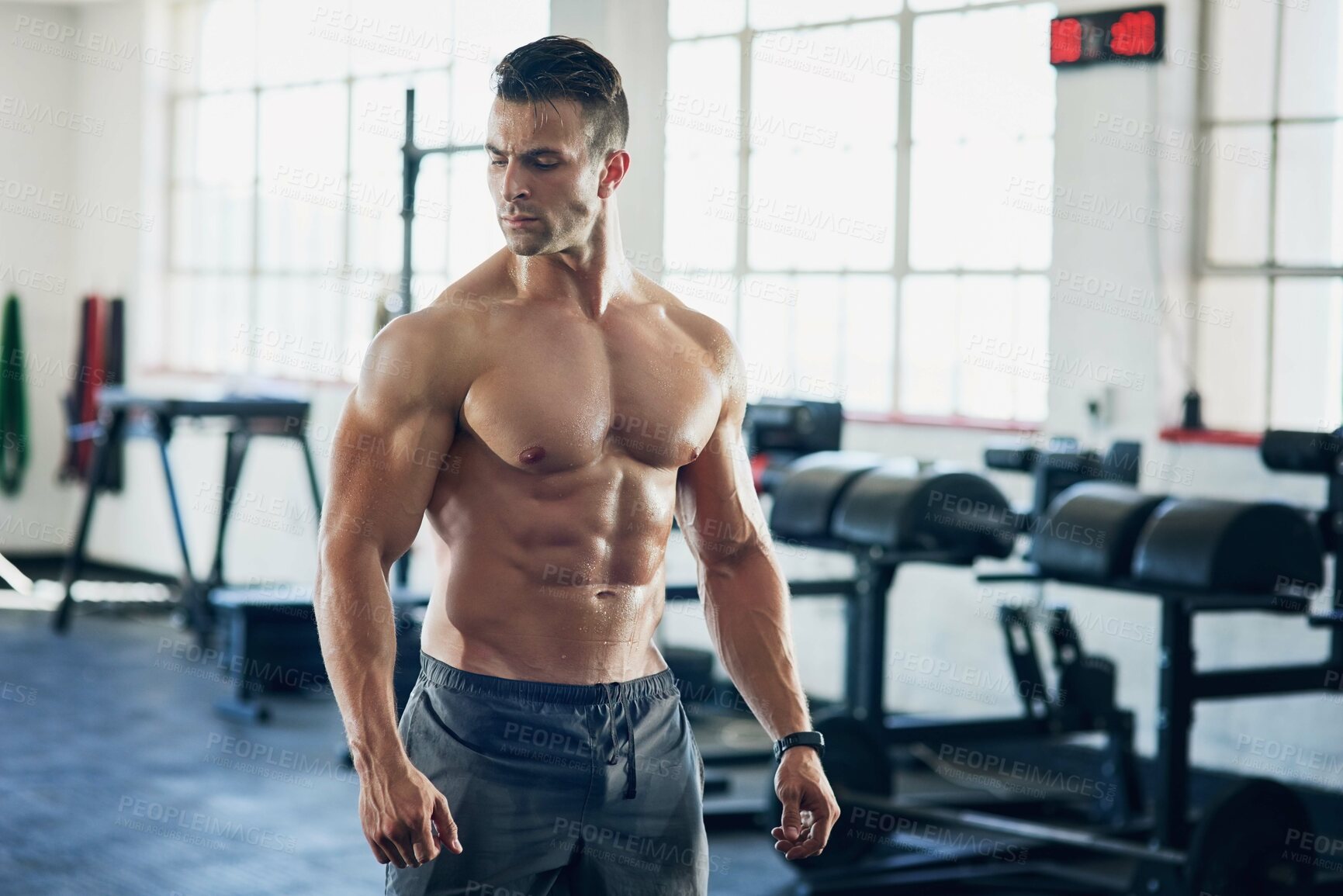 Buy stock photo Shot of a handsome young man working out at the gym