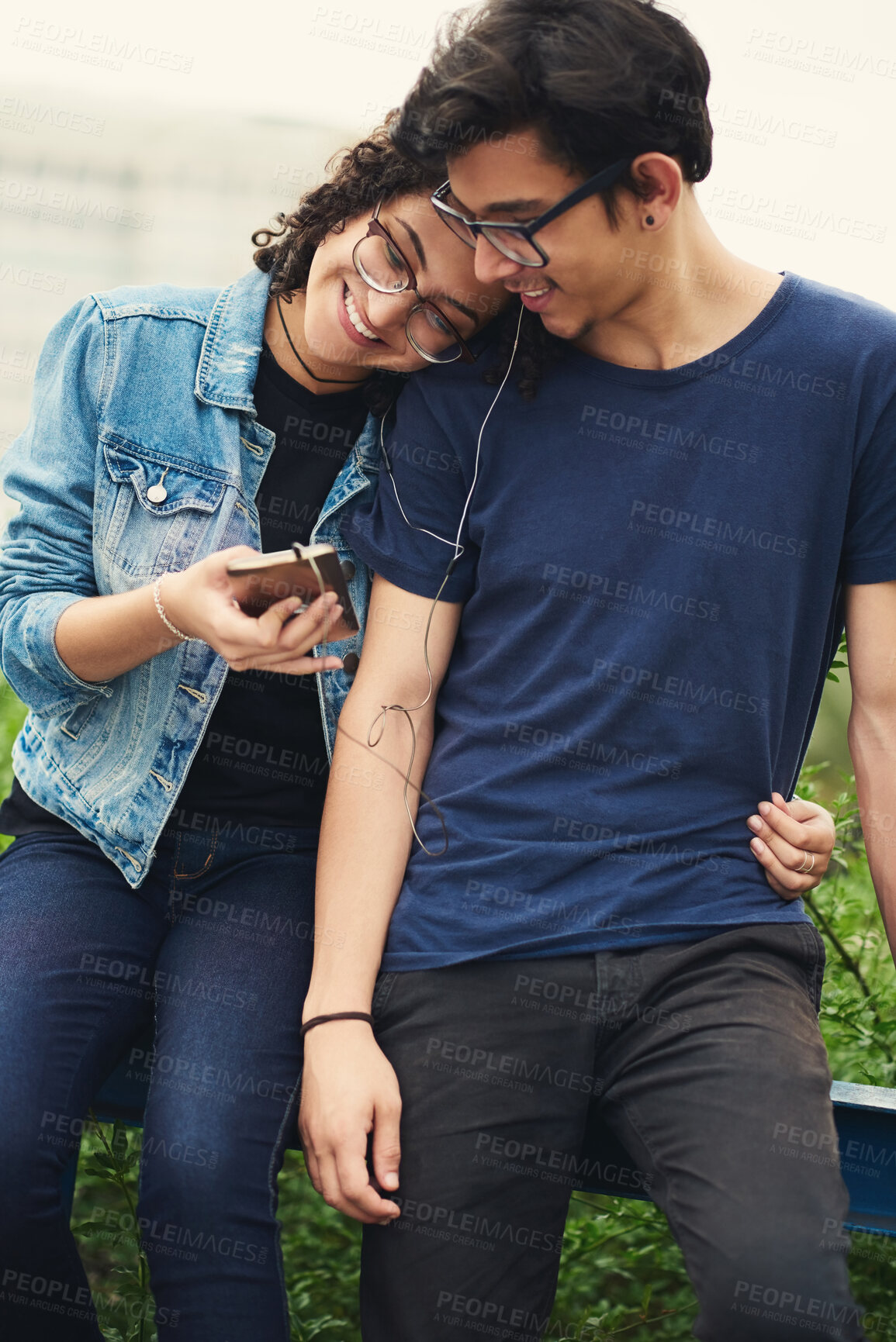 Buy stock photo Couple, teenager and music outdoor for relax, bonding and social media together on weekend with romance. Boy, girl and happy for relationship, earphones and listening in park with love connection