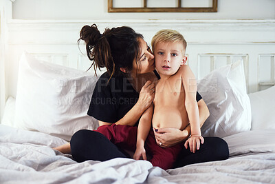 Buy stock photo Mother, kiss and child in home with family, bedroom and love together on weekend with parenting. Care, support and young boy with morning, relax and bed with sweet, cute and youth development