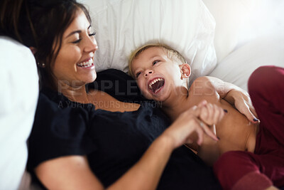 Buy stock photo Happy, laughing and mom with child on bed for bonding, love and fun relationship in morning. Family, home and mother with young boy in bedroom for tickle, joke and relaxing together on weekend