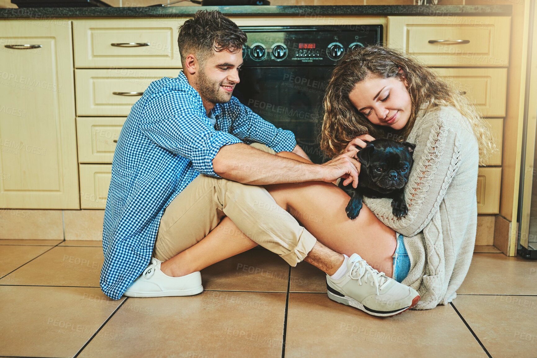 Buy stock photo Happy couple, pet and play with dog on kitchen floor for care, morning and love for cute puppy. Man, woman and relax with pug animal for game, connection or bonding together for relationship in home