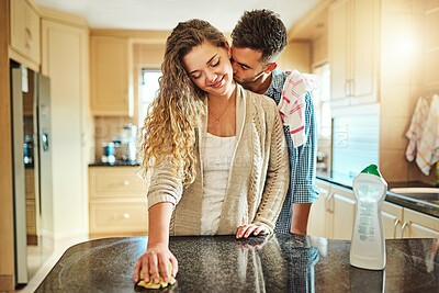 Buy stock photo Couple, kiss and cleaning with disinfectant on table for hygiene, bacteria or germ removal in kitchen at home. Happy, woman or man with affection or cloth for wiping dirt, sanitary or housekeeping