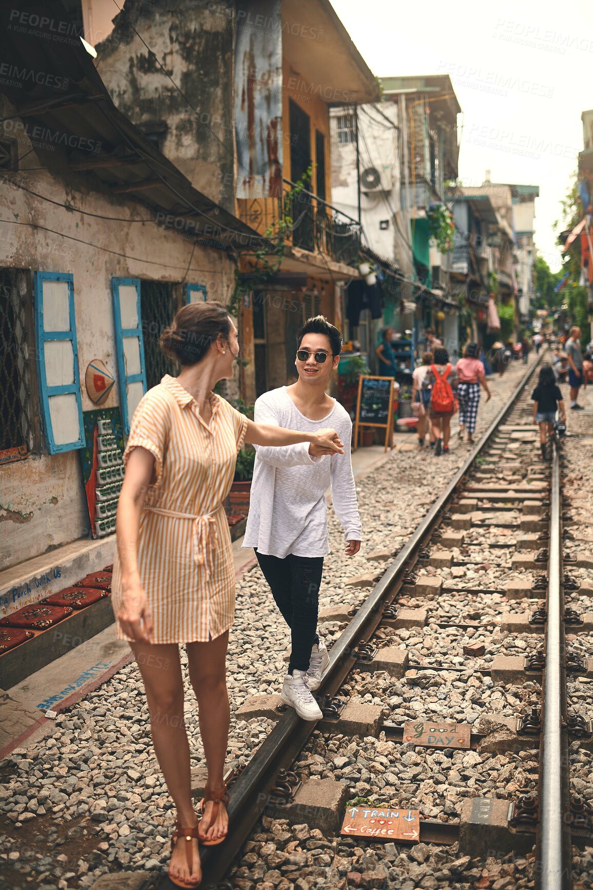 Buy stock photo Couple, romance and walking by railway for travel, relationship and holiday adventure with support. People, trip and happy in Vietnam for vacation, love and holding hands on date with train track