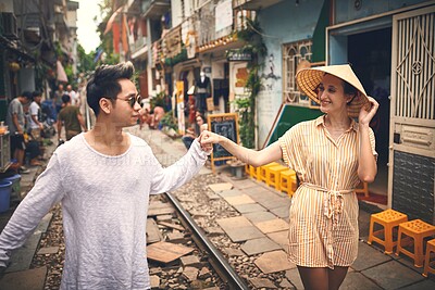 Buy stock photo Couple, love and holding hands by railway for travel, relationship and holiday adventure with support. People, trip and happy in Vietnam for vacation, romance and walking on date with train track