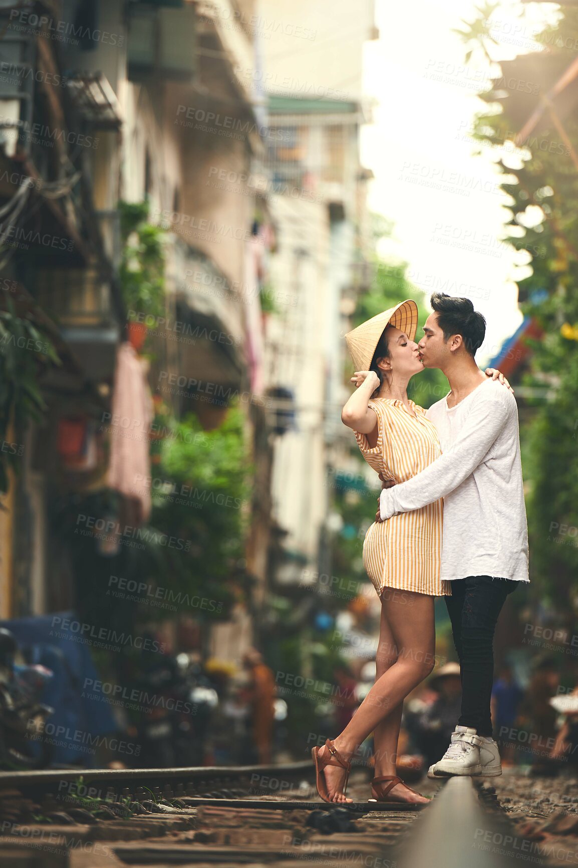 Buy stock photo Kiss, travel and couple in city for vacation, sightseeing and holiday for romance in relationship. Outdoor, love and woman hug man for bonding together in urban town for weekend trip in Vietnam.