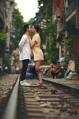 Buy stock photo Love, kiss and couple on train tracks in Vietnam for holiday, vacation and tourist destination. Embrace, weekend and man and woman on railway for adventure, journey and travel for bonding in city