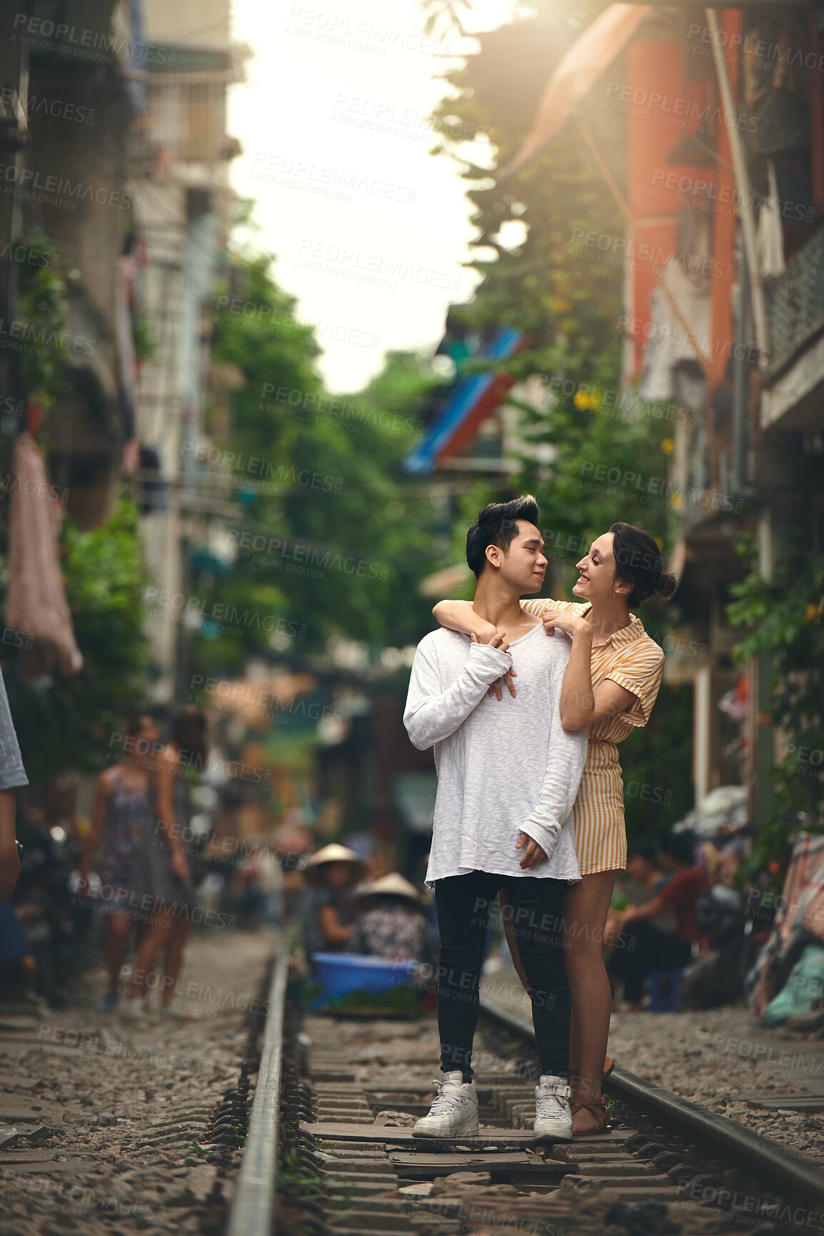 Buy stock photo Happy, travel and couple hug in city for vacation, sightseeing and holiday for romance in relationship. Train track, love and woman embracing man for bonding in urban town for weekend trip in Vietnam