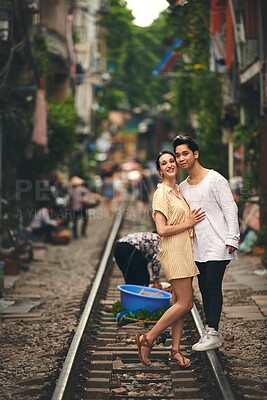 Buy stock photo Travel, portrait and couple on train tracks in Vietnam for holiday, vacation and tourist destination. City architecture, love and happy man and woman on railway for adventure, journey and bonding