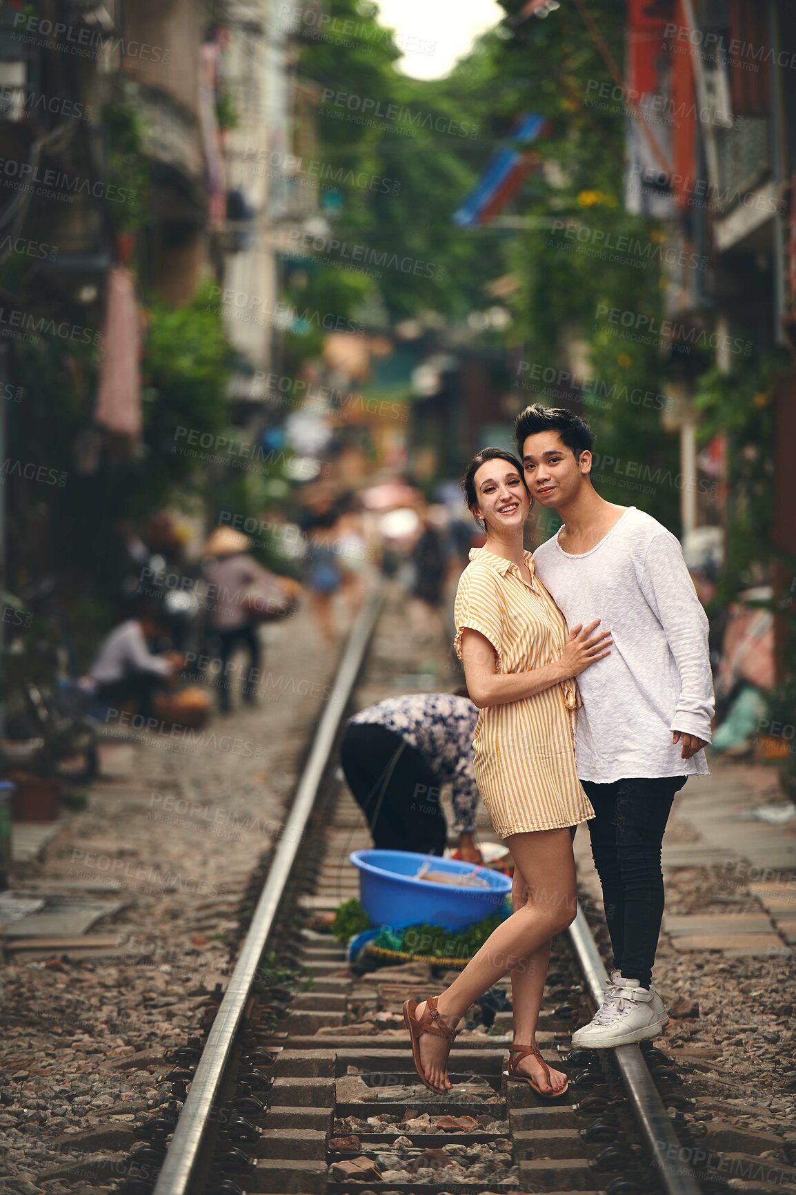 Buy stock photo Travel, portrait and couple on train tracks in Vietnam for holiday, vacation and tourist destination. City architecture, love and happy man and woman on railway for adventure, journey and bonding