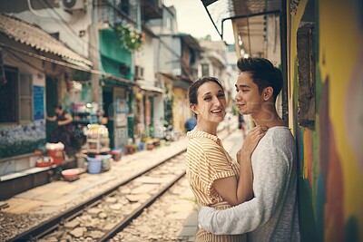 Buy stock photo City, tramway and couple in portrait on vacation, travel adventure and exploring for anniversary. Interracial marriage, woman and man with smile for admiration, hug and bonding outdoor in Vietnam