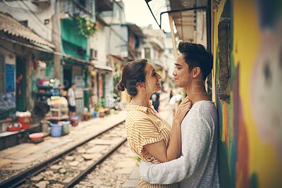 Buy stock photo City, tramway and couple with hug on vacation, travel adventure and exploring for anniversary. Interracial marriage, woman and man with smile for admiration, romance and bonding outdoor in Vietnam