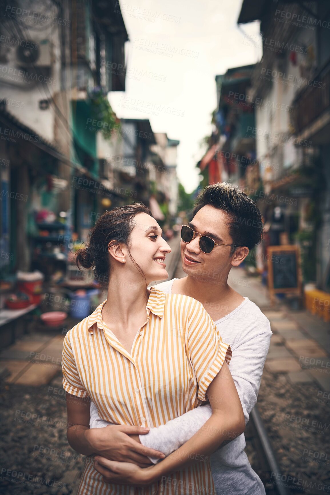 Buy stock photo Couple, happy and hug in city for love, romantic gesture or healthy relationship with trust. Man, woman and support on Vietnam railway for sweet moment, affection and travel outing with commitment