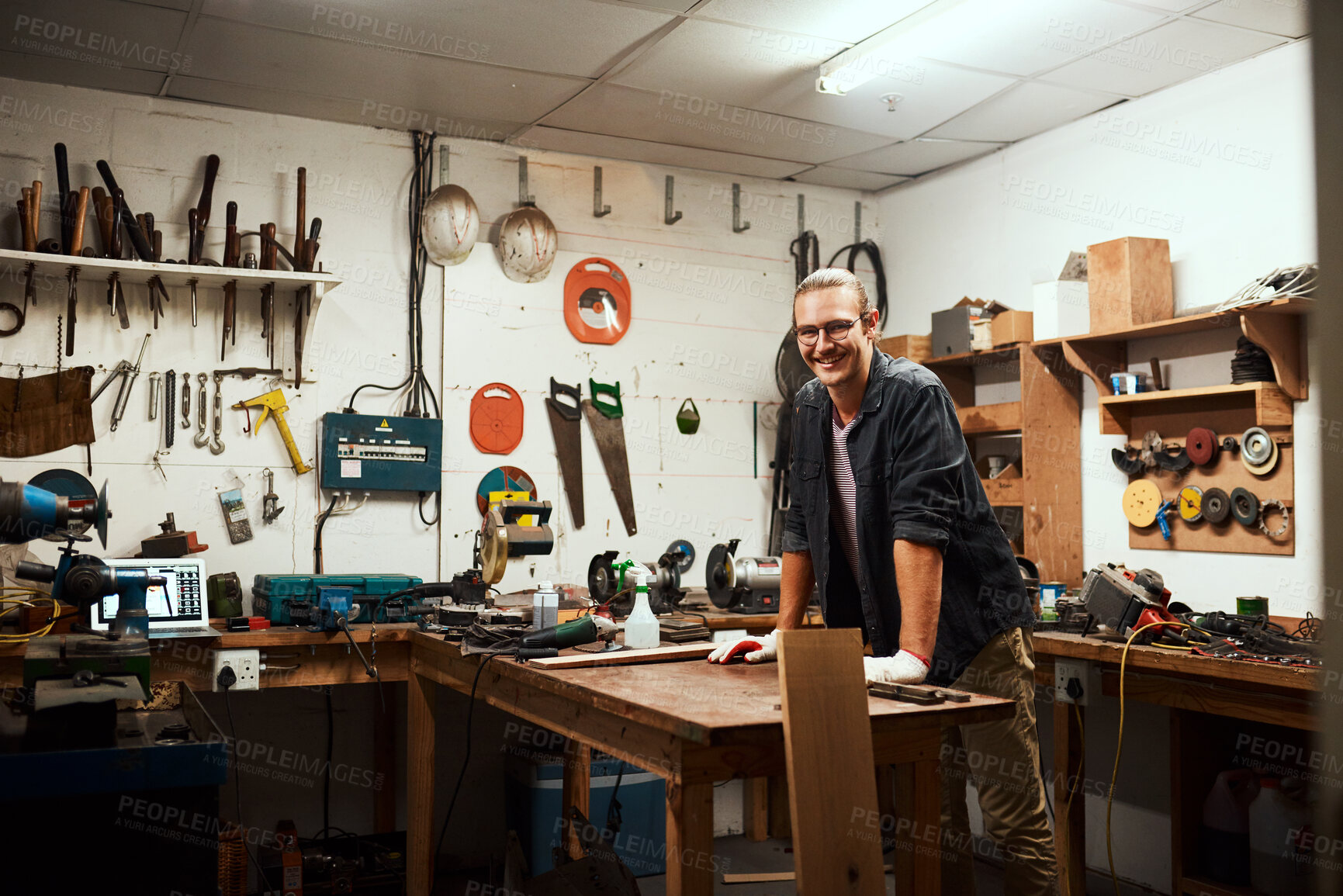 Buy stock photo Happy man, portrait or carpenter with workbench or tools for project or woodwork at manufacture. Young, male person or designer with smile, material or equipment for DIY, artisan or craft at workshop