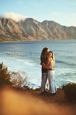 Buy stock photo Ocean, portrait and couple with kiss on adventure, travel vacation and bonding together with hug. Mountain, man and woman with smile for anniversary, connection and holiday with affection by flare