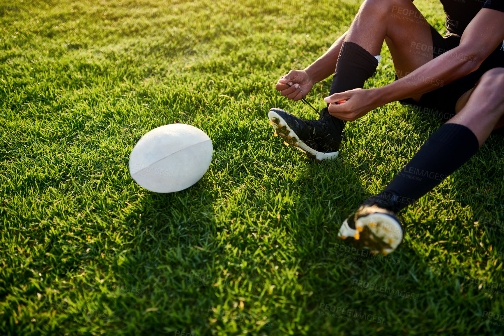 Buy stock photo Man, tying laces and rugby ball for outdoor, game or challenge in exercise, wellness or fitness. Male person, athlete and shoes in recreation facility or arena for match, sport or training in stadium