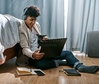 Buy stock photo Man, dog and headphones with laptop at house for streaming, listening to music and reading email. Male student, puppy and online communication for education, inspiration podcast and studying schedule