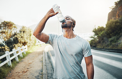 Buy stock photo Drinking water, fitness and road with African man and headphones for music or podcast streaming. Outdoor, exercise and hydration with audio, wellness and training on street with health in Mozambique