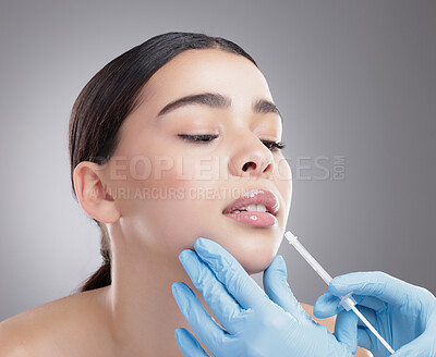 Buy stock photo Woman, hands and lip injection in studio, skincare and cosmetic service on gray background. Female person, needle and plastic surgery or collagen treatment, syringe and hyaluronic filler or beauty