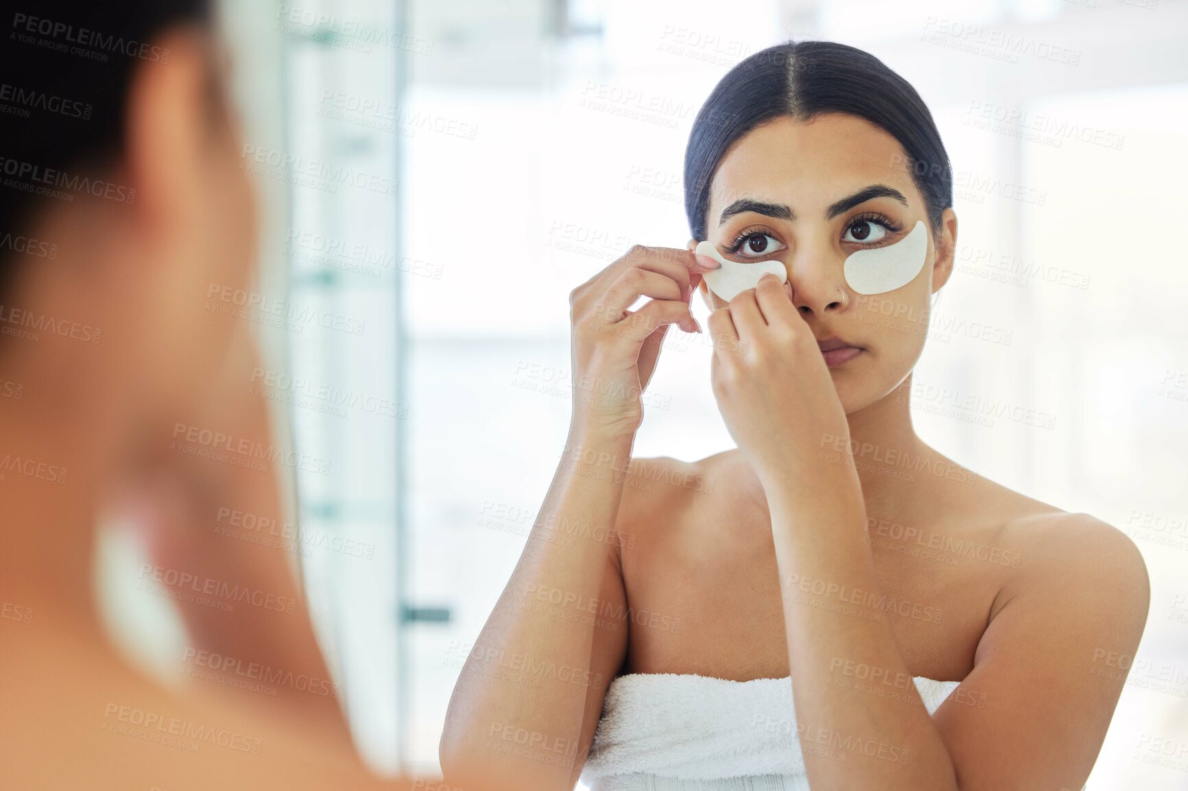 Buy stock photo Woman, home and skincare with eye patch on mirror for antiaging, beauty and glow with self care. Female person, towel and bathroom in apartment with treatment for dark circles, facial and grooming