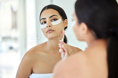 Buy stock photo Woman, jade roller and eye patches on mirror at bathroom for skincare, beauty and glow with self care. Female person, home and moisturizer for fresh skin, grooming and facial treatment or routine