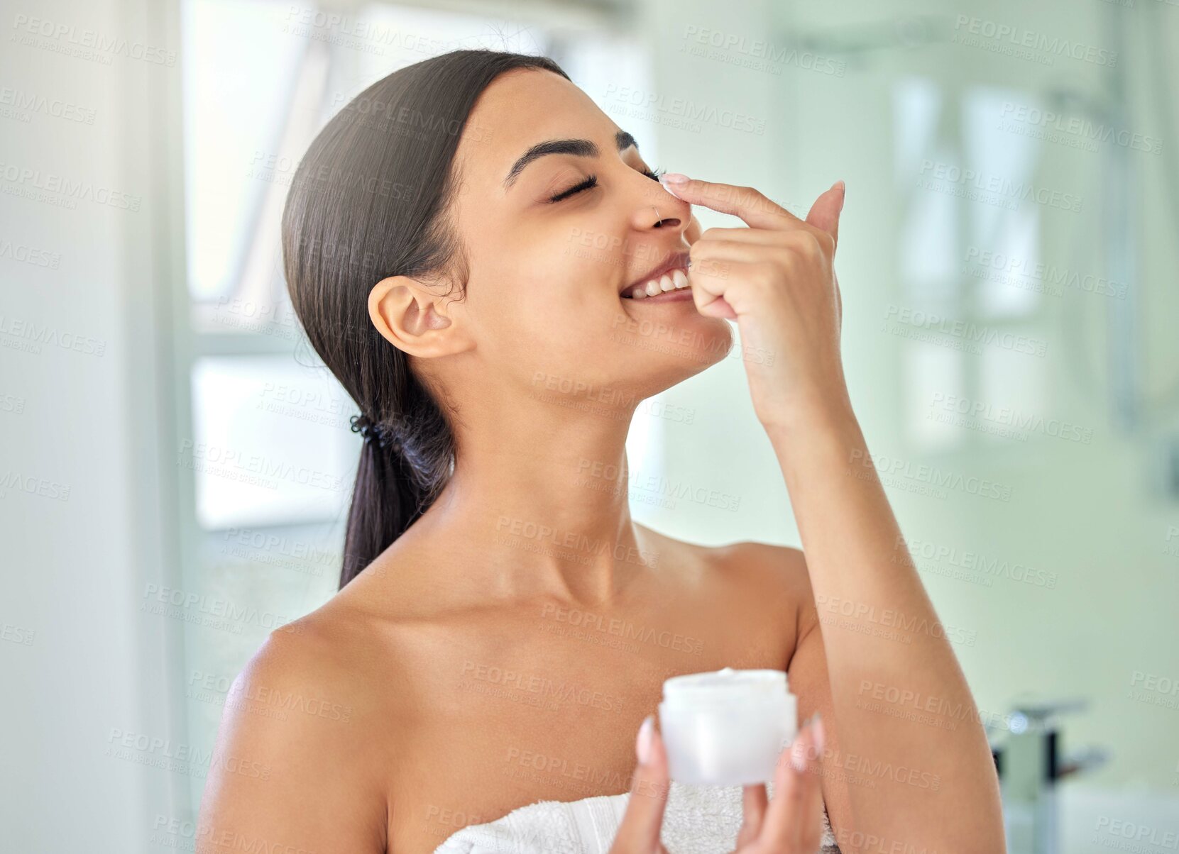 Buy stock photo Beauty, lotion and nose with woman in bathroom of home for morning skincare routine or wellness. Cream, eye closed and smile of happy person in towel at apartment for facial dermatology treatment