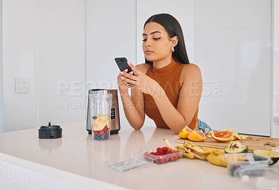 Buy stock photo Woman, phone and prepare smoothie in home, cooking and fruit for mineral liquid in kitchen. Female person, nutrition and online for social media blog on diet, breakfast cocktail and blender detox