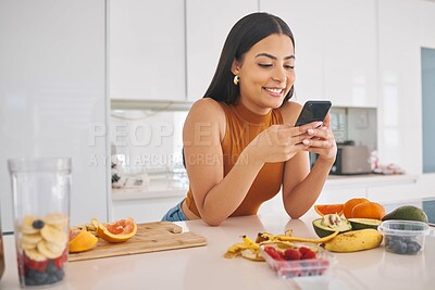 Buy stock photo Woman, phone and fruit for breakfast in home, cooking and prepare mineral liquid in kitchen. Female person, nutrition and online for social media blog on diet, smoothie cocktail and typing message