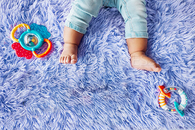 Buy stock photo Baby toys, infant and feet with carpet for childcare, development and motor skills in family home. Toddler, legs and growth as little girl for curious, play and learning in safety, security and house