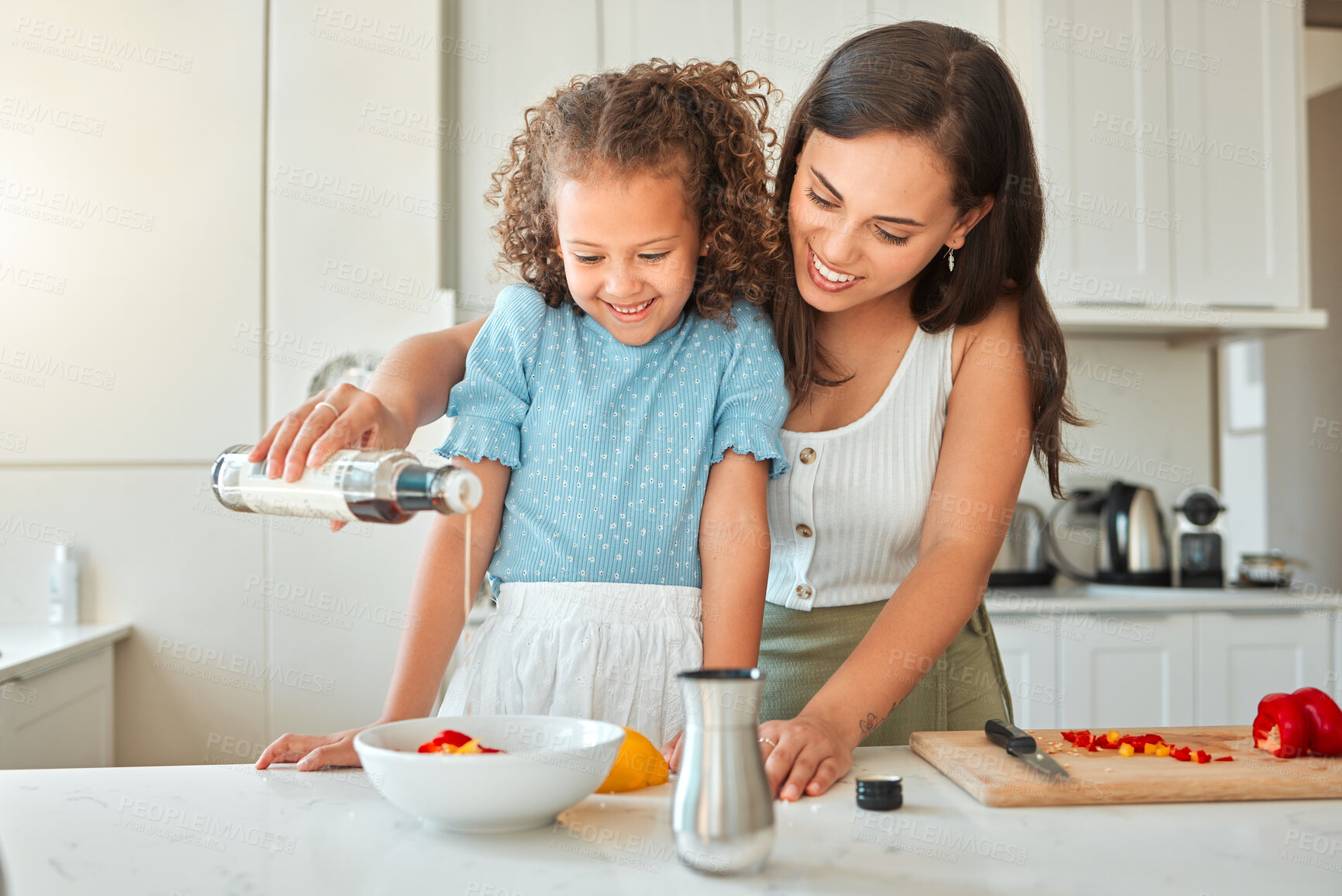 Buy stock photo Mother, girl and teaching with salad dressing, smile and guidance for cooking and seasoning in kitchen. Woman, child and learning with vegetables for dinner, meal and healthy diet with fun at home