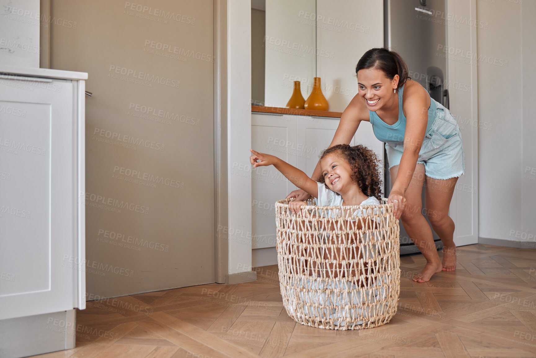 Buy stock photo Push, laundry and basket with mother and daughter in house for support, cleaning and helping. Happiness, playful and housekeeping chores with woman and child in family home for linen, crazy and love