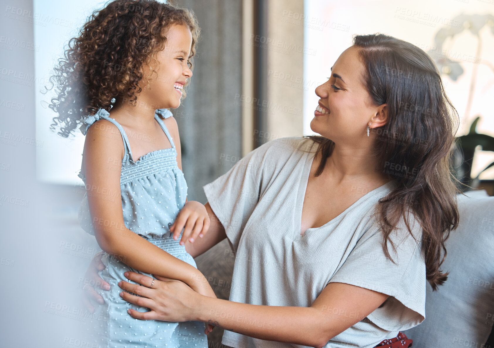 Buy stock photo Smile, play and mom on sofa with child for morning bonding,  growth and support in happy family home. Love, mother and daughter on couch with playful embrace, care and fun in living room together