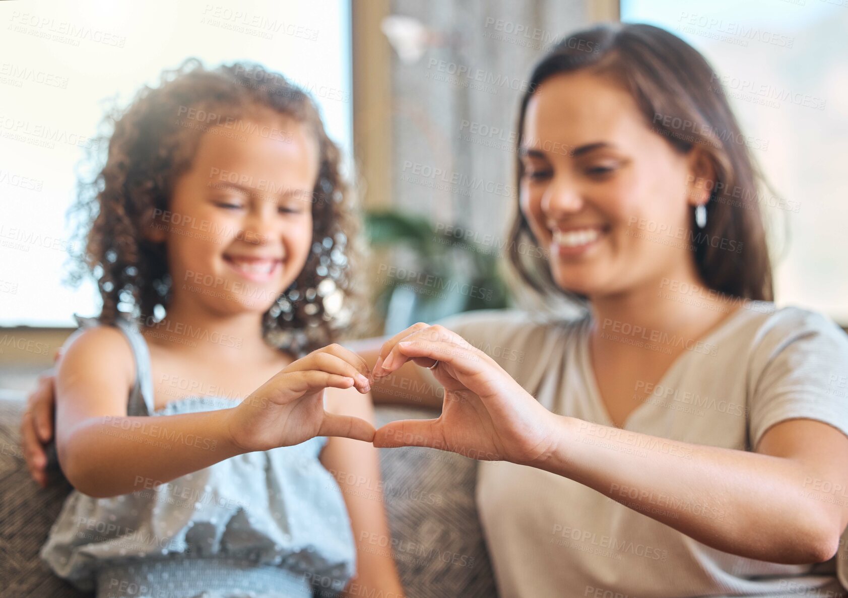 Buy stock photo Mother, girl and heart hands in home for support, love and emoji for trust in relationship. Mama, daughter and together in living room with symbol of care, happiness and sign on couch for connection