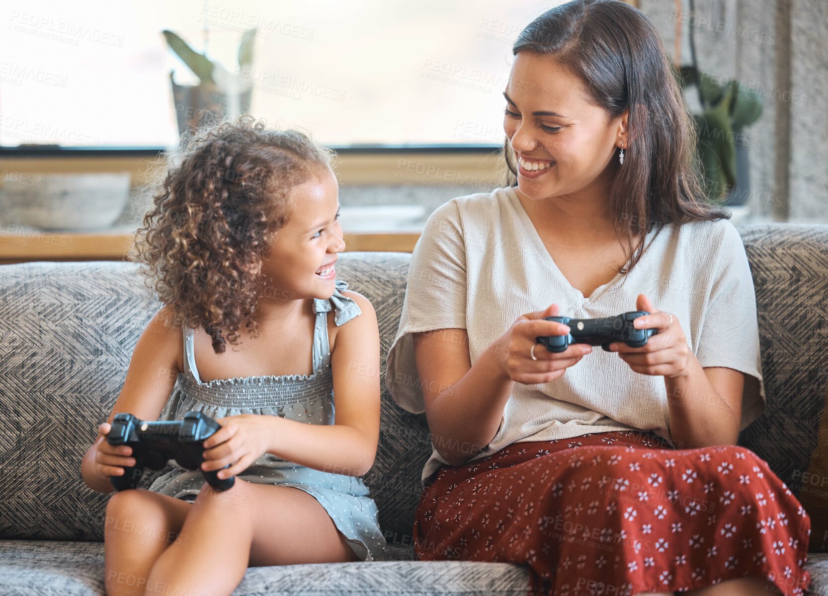 Buy stock photo Mother, girl and video games in home, controller and online competition or match in living room. Mama, daughter and streaming challenge for entertainment, bonding and playing together in apartment