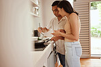 Adult couple at home cooking food, learning a skill and tasting a recipe from wok in the kitchen together. Relaxed leisure time, preparing a meal, making dinner in a pan with the chef at home.