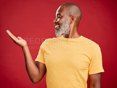 Buy stock photo Hand, mockup and smile with mature black man in studio isolated on red background for presentation. Advertising, marketing and space with happy African person holding offer or promotion in palm