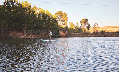 Buy stock photo Man, holiday and paddle board in lake for travel with adventure, summer vacation and fitness. Person, balance and floating in river for wellness, workout and water exercise for hobby in countryside