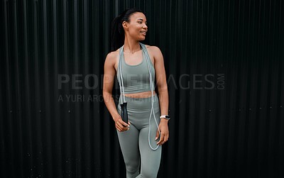 Buy stock photo Fitness, skipping rope and woman in city for workout, health and wellness with endurance training. Sports, equipment and female athlete with cardio exercise by black wall in town for weightloss.