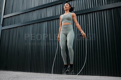 Buy stock photo Athlete, girl and jumping with rope outdoor for fitness, sports training and energy of health workout. Active, woman and leap with cardio performance, endurance exercise and competition practice