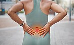 Closeup shot of a young african american woman suffering with back pain while working out in the city. Superimposed cgi highlighting an injury where a female athlete is struggling with lower back ache